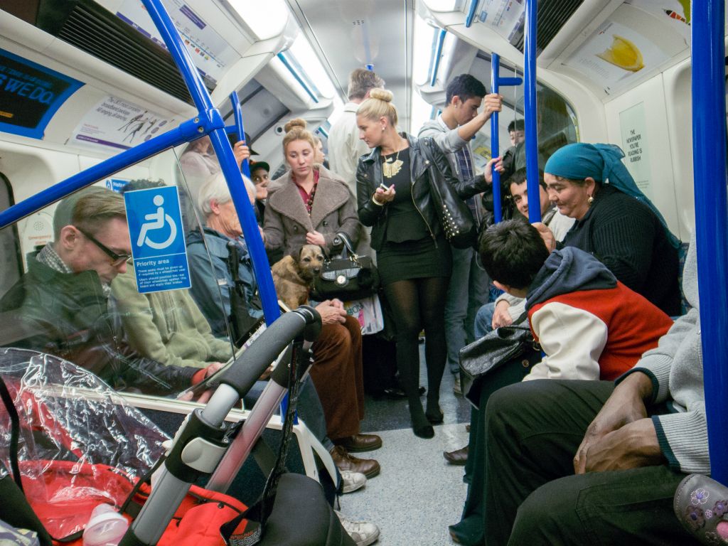 Several people converse on the tube at London Victoria.
